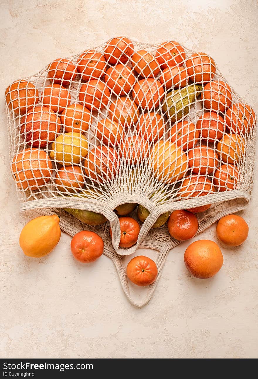 Cotton mesh shopping bag with fruit on background. Zero waste concept. Green, ecology