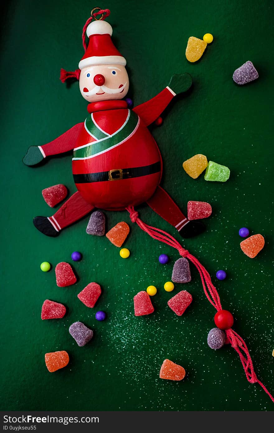 Vintage wooden Santa with red pull string to move his arms and legs, surrounded my colorful gumdrop candy. Vintage wooden Santa with red pull string to move his arms and legs, surrounded my colorful gumdrop candy