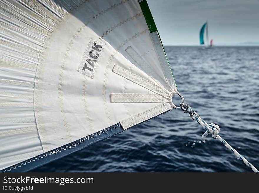 The sailboat goes on sails, a view of the sea and other sailboats through a sail and ropes