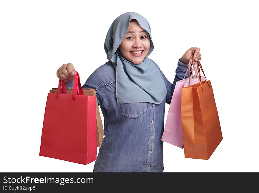 Portrait of happy Asian muslim woman brings shopping bags, isolated on white, consumerism lifestyle concept. Portrait of happy Asian muslim woman brings shopping bags, isolated on white, consumerism lifestyle concept