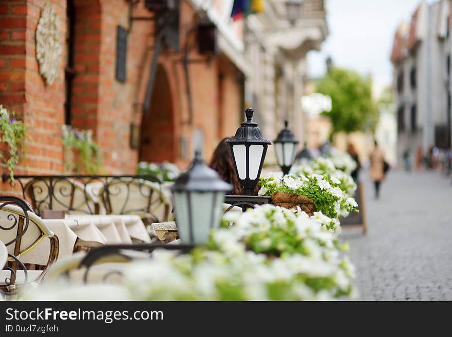 Outdoor restaurant table decorated with plants and flowers in Vilnius, Lithuania, on nice summer day