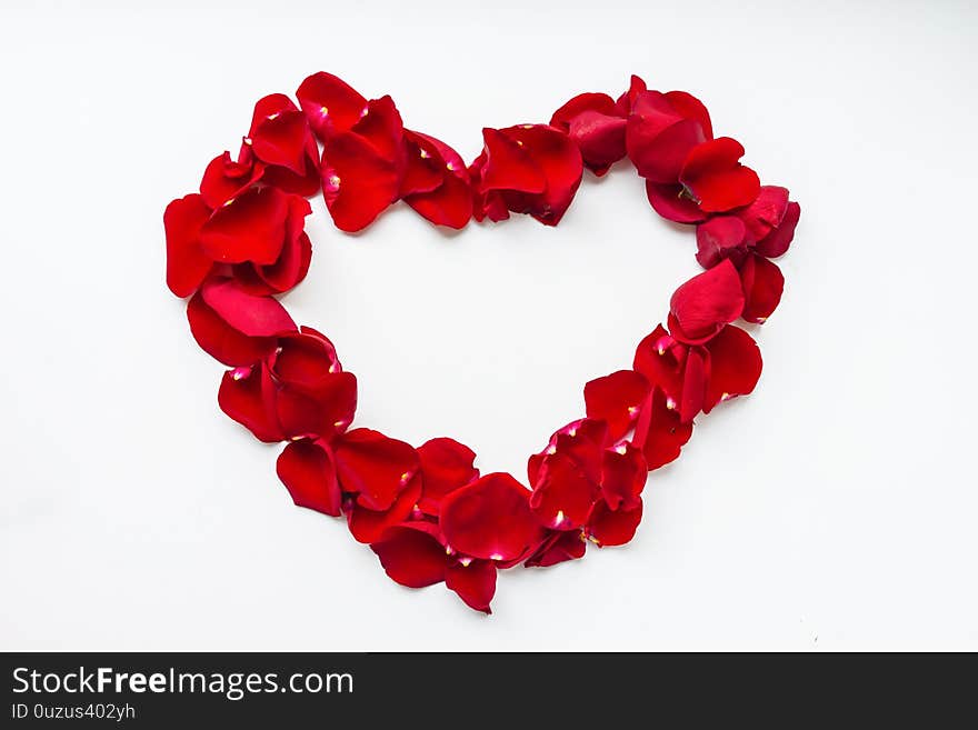 Heart shaped red rose petals. Greeting card for the holiday.