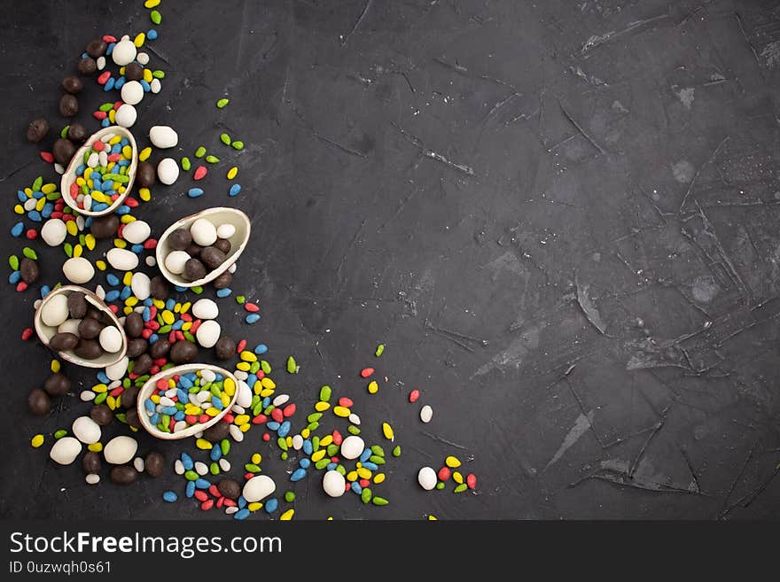 Chocolate easter eggs and sweets on dark background.