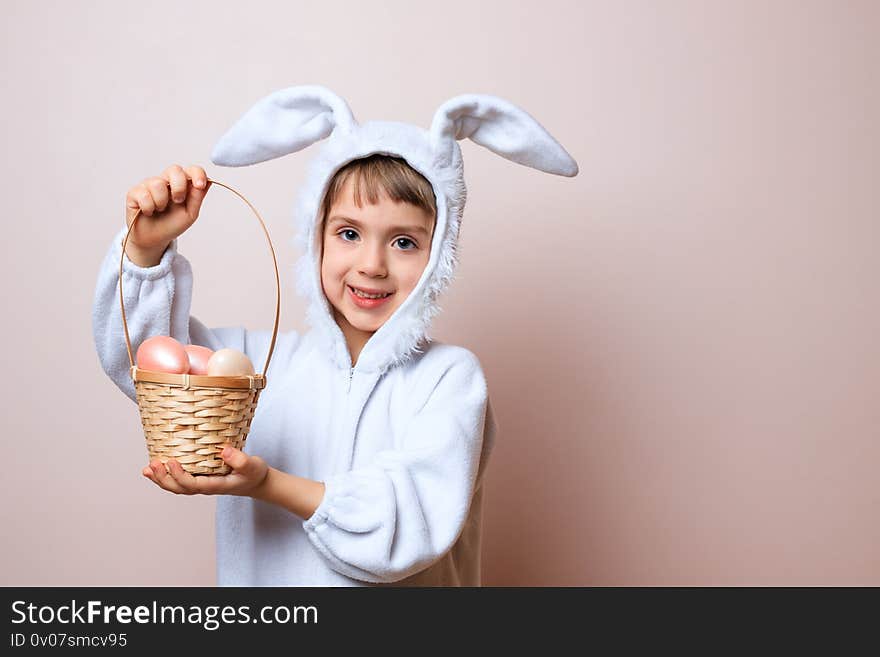 Cute little child girl wearing bunny costume on Easter day. Girl hunts for Easter eggs on pink background. Girl with Easter eggs in the basket. Place for your text. Cute little child girl wearing bunny costume on Easter day. Girl hunts for Easter eggs on pink background. Girl with Easter eggs in the basket. Place for your text