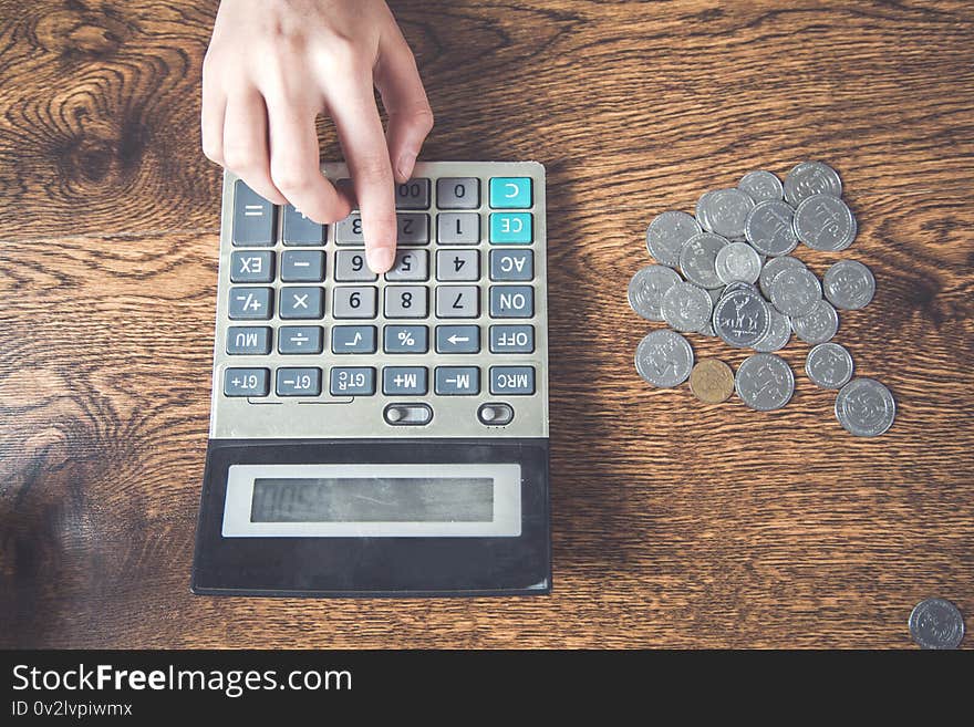 Woman hand coins with calculator  on desk