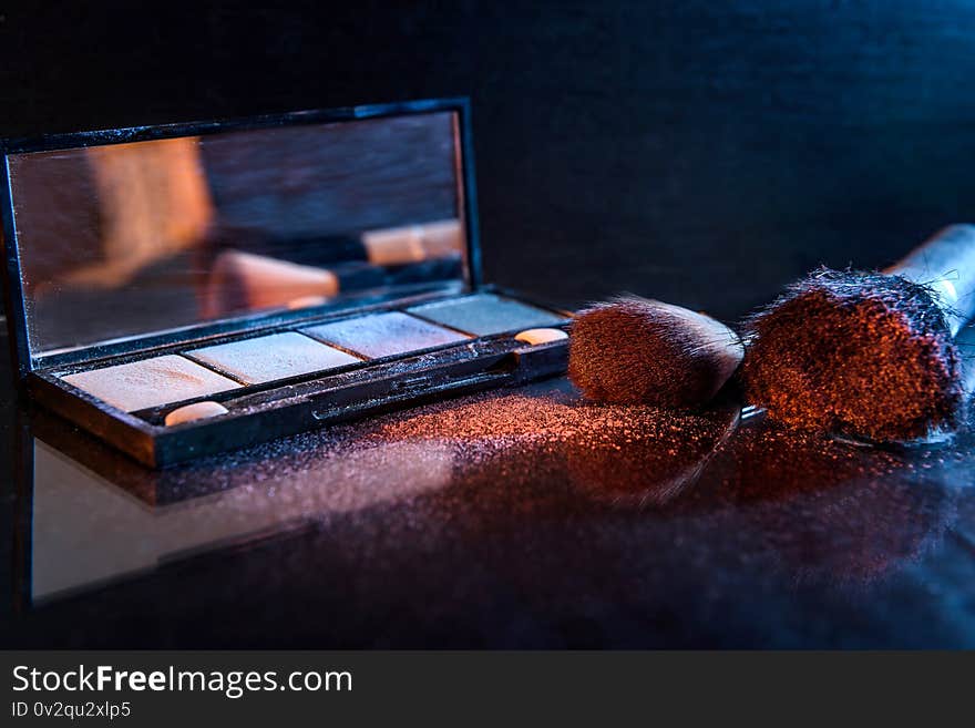 Makeup set with brushes and dust on dark background