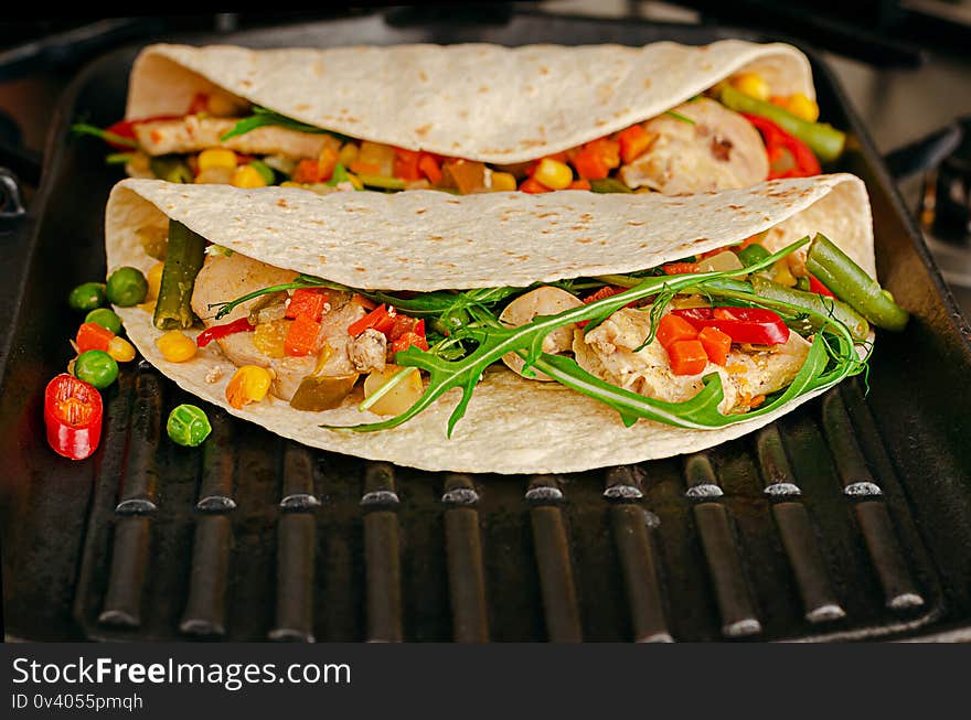 Delicious Mexican food. Tacos with vegetables and chicken on grill pan. Copy space