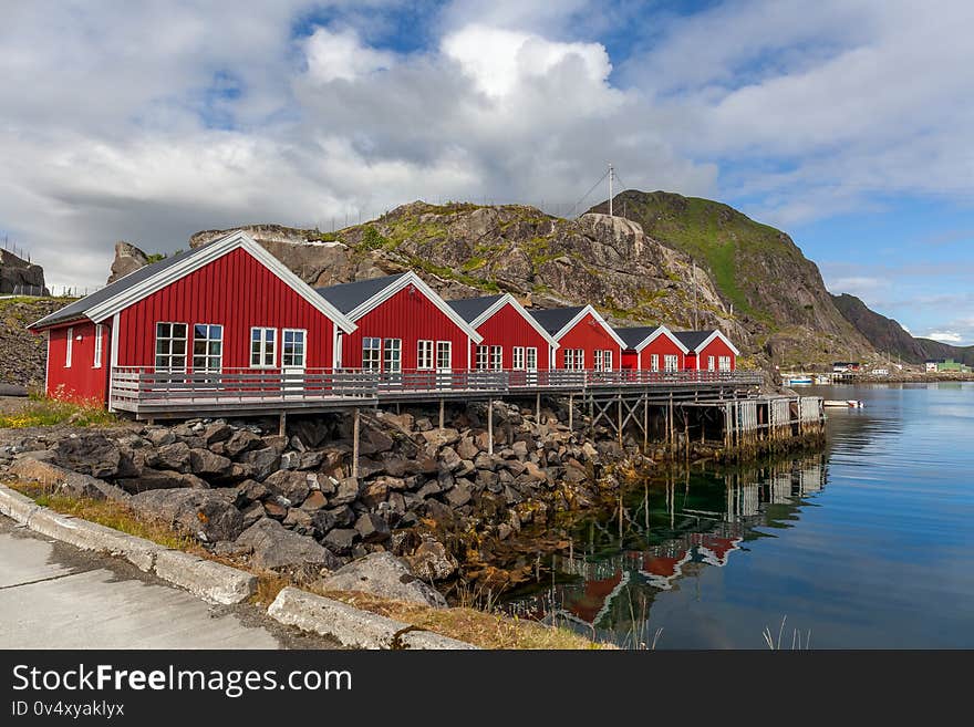 Typical Norwegian fishing village with traditional red rorbu huts, Reine, Lofoten Islands, Norway. Typical Norwegian fishing village with traditional red rorbu huts, Reine, Lofoten Islands, Norway