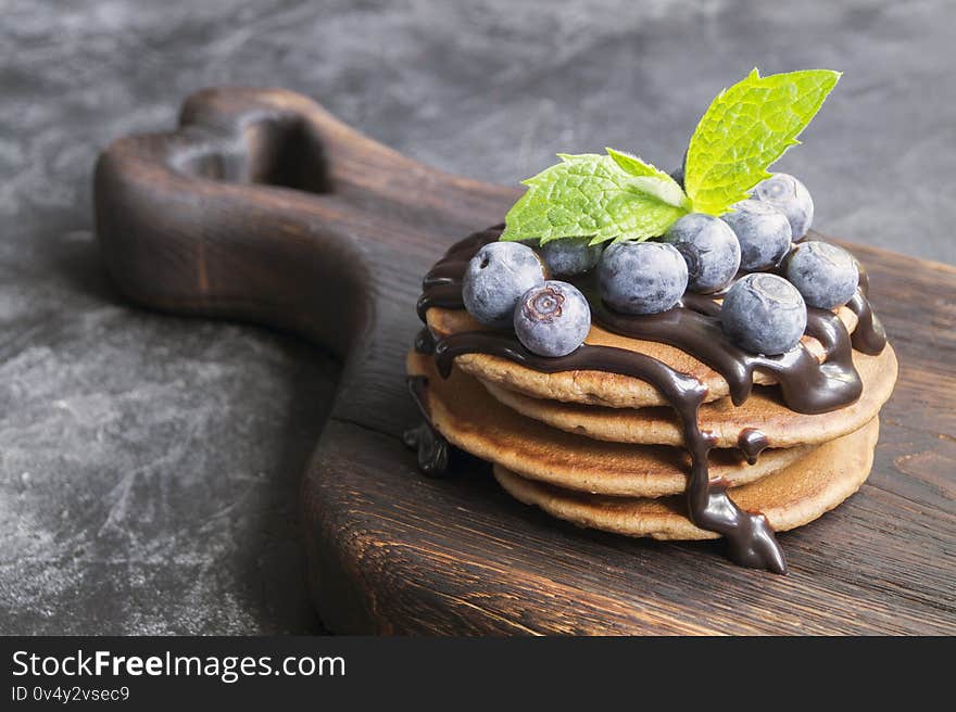 chocolate pancakes with chocolate syrup. on a wooden Board