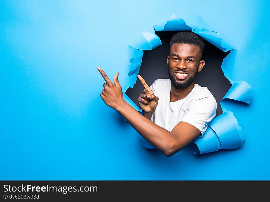 Handsome young black man with head through a cardboard paper smiling and happy. Handsome young black man with head through a cardboard paper smiling and happy