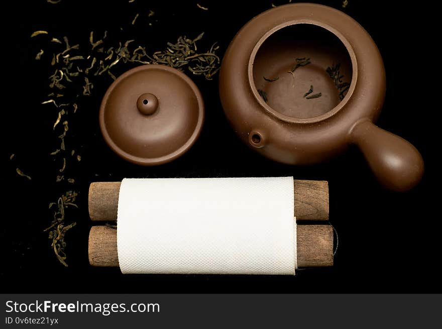 Traditional Chinese teapot and green tea on black background. Natural healthy drink