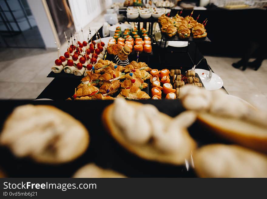 Beautifully decorated catering banquet table with different food snacks and appetizers with sandwich