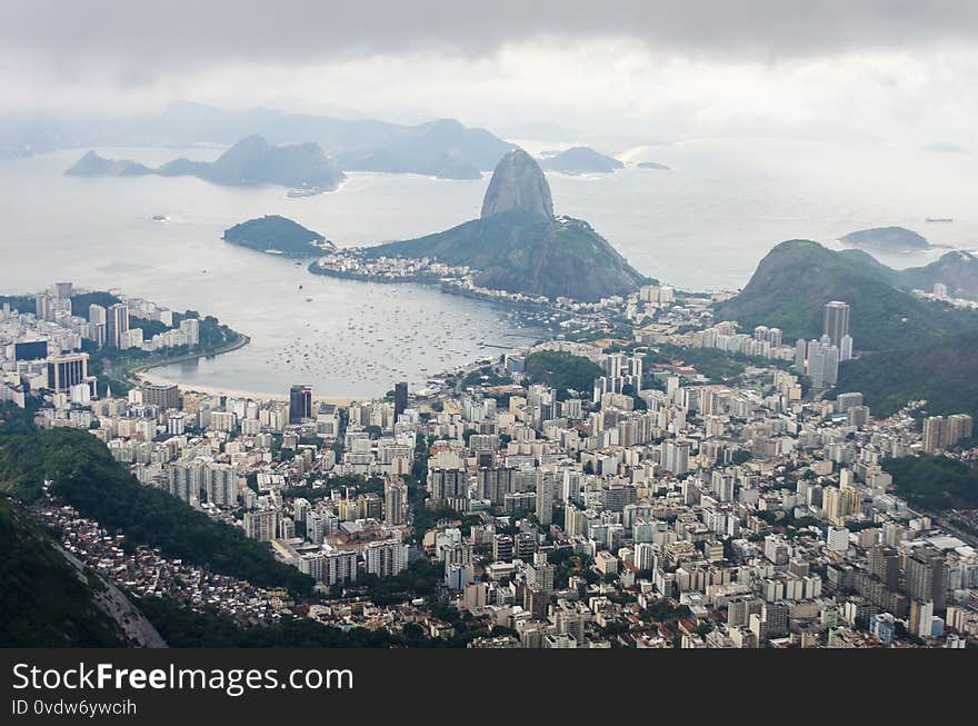 View of Rio de Janeiro from the Christ The Redeemer statue, with the Sugarloaf Mountain at the end of Botafogo Bay. View of Rio de Janeiro from the Christ The Redeemer statue, with the Sugarloaf Mountain at the end of Botafogo Bay