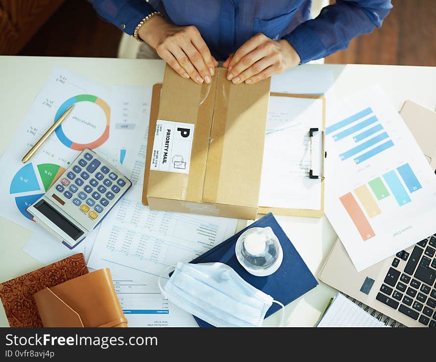 Upper view of business woman at table opening parcel