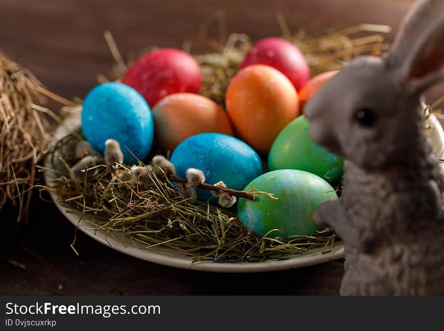 Easter bunny and a plate with colored eggs. Easter celebration concept. Close-up