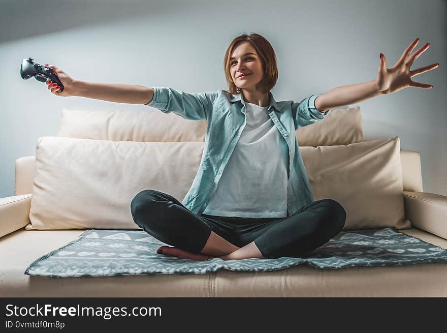 Portrait of a girl with a joystick in her hands. The concept of video games, computer consoles. Stay home