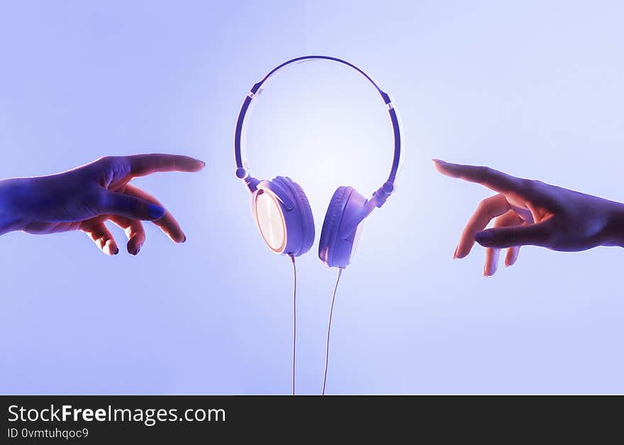 Hands of guy and girl reach for headphones