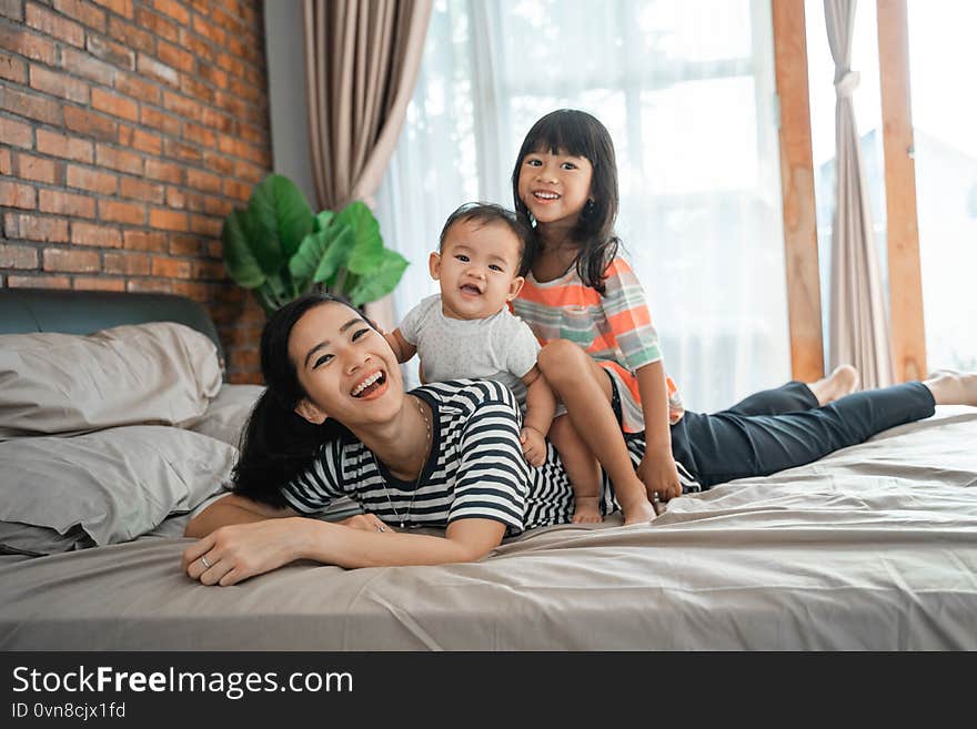 Children sitting on mother`s back playing