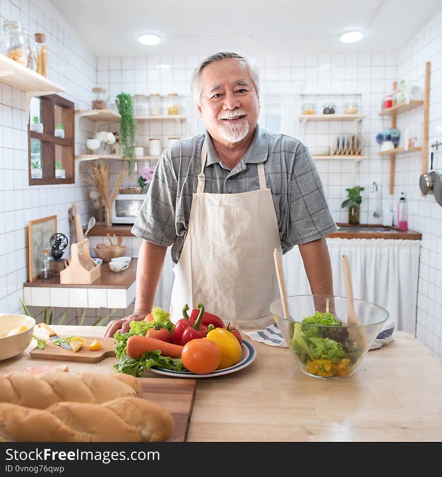 Portrait of happy senior elderly asian grandmother standing cooking meal in kitchen,Old women prepare dinner in hobby lifestyle.