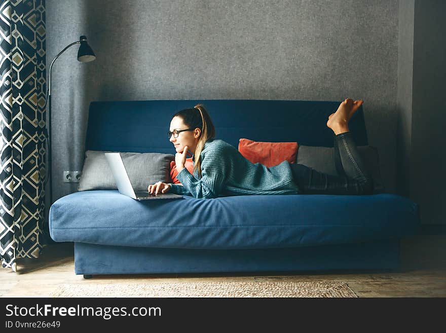 Girl working on laptop from home or student studying from home or freelancer. Or she is watching a video or using the Internet