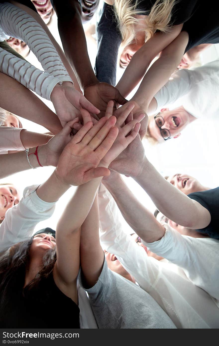 Bottom view . group of young people joining their palms together . the concept of team building