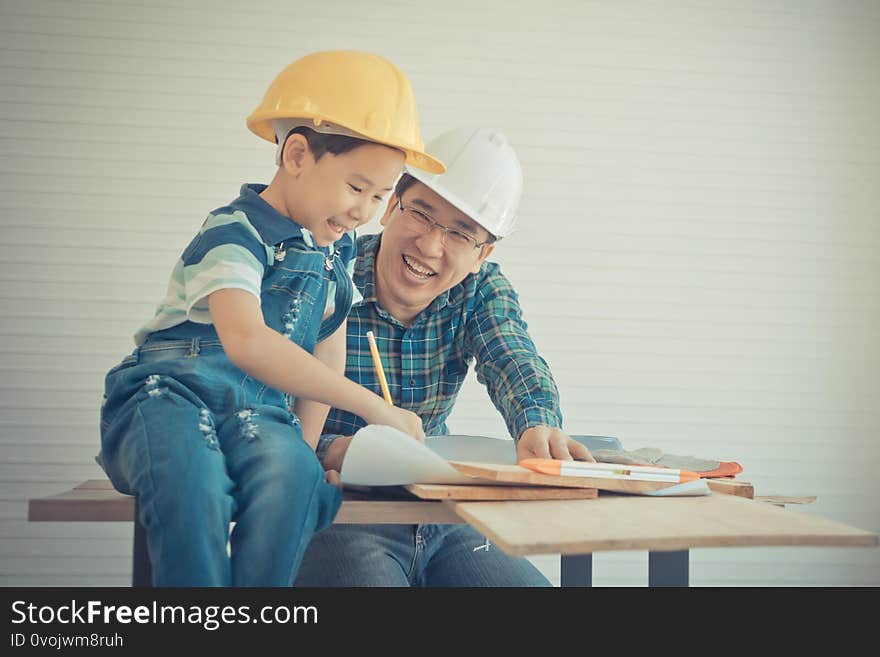 Father is teaching his son to fo the DIY home improvement work for parent and family bonding concept