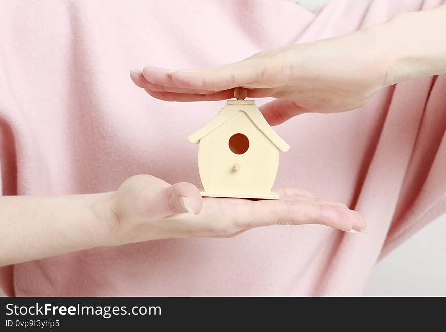 Woman holding tiny wooden house. Idea of life