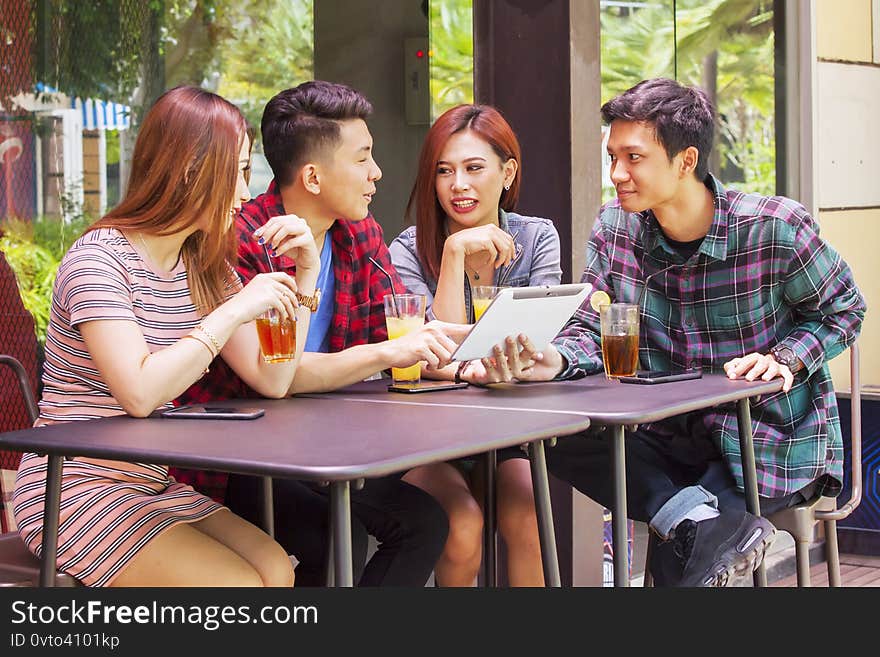 Young people using digital tablet in restaurant