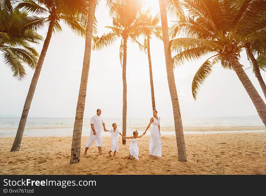 Happy young family on the sunset at the beach.