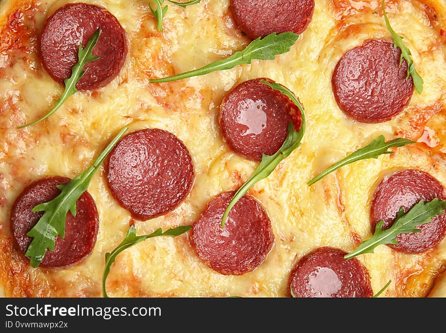 Tasty pepperoni pizza with arugula as background