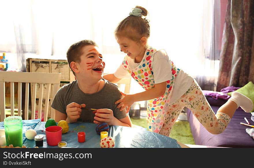 Funny kids with stained faces having fun at home in the kitchen. Brother and little sister. Funny. Creative concept. Mess at home. Normal quarantined life. Lifestyle