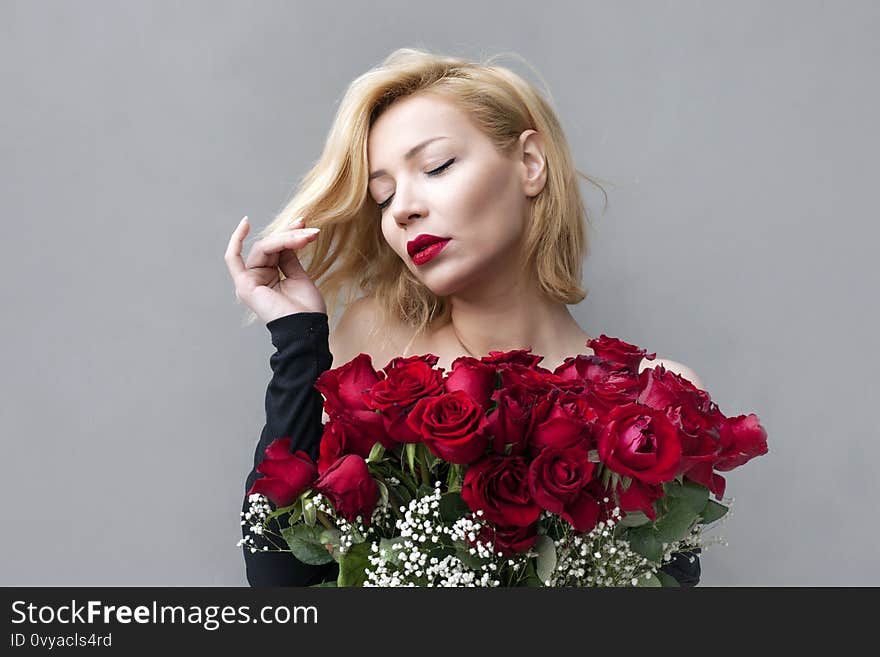 Smiling girl with bouquet of red roses