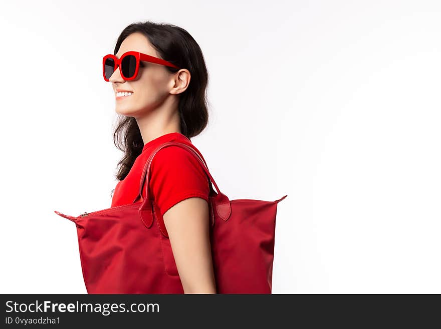 Fashionable woman hold shopper bag, wear retro sunglasses with happy face. Attractive beautiful young lady going to shopping in