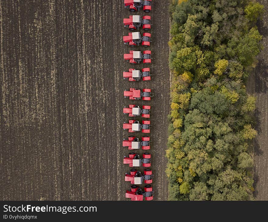 Red tractors on farmland.