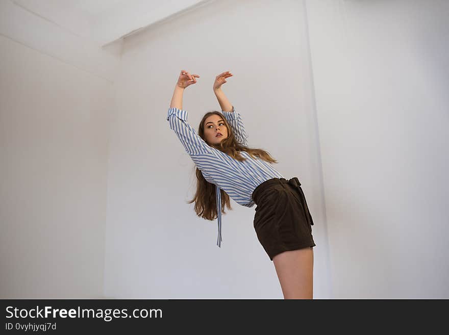 Young beautiful girl in a shirt and shorts is dancing in the style of contemp. Young beautiful girl in a shirt and shorts is dancing in the style of contemp.