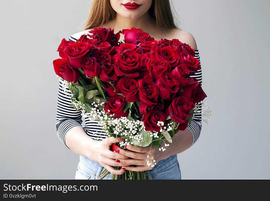 Smiling girl with bouquet of red roses