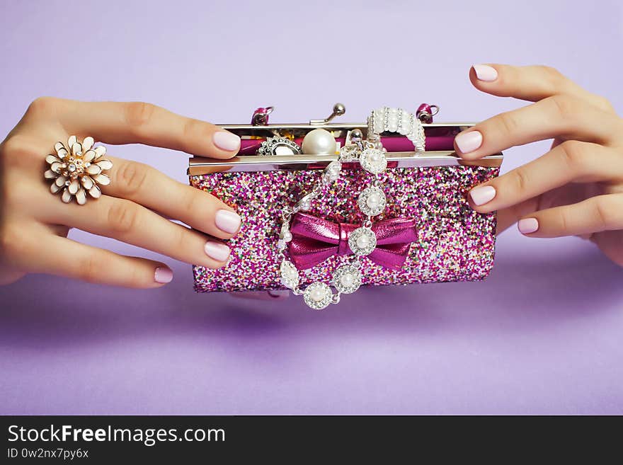 Little girl stuff for princess, woman hands holding small cute handbag with jewelry and manicure, luxury lifestyle