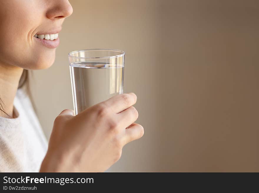 Smiling woman with drinking water in glass indoors. Smiling woman with drinking water in glass indoors