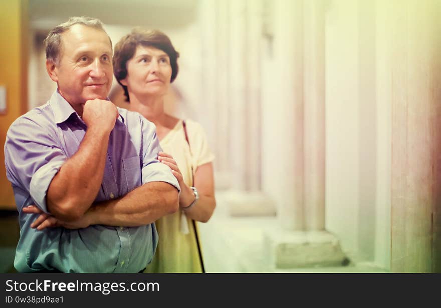 Mature couple turists examines the exhibit in historical museum. Mature couple turists examines the exhibit in historical museum