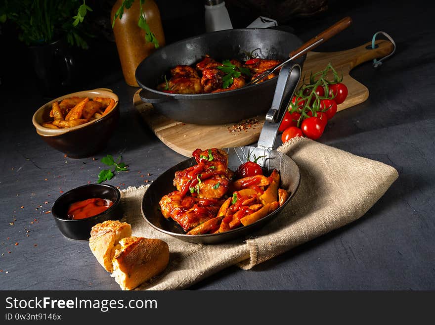 Rustic chicken wings in honey with potato wedges