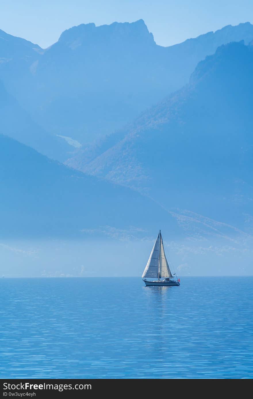 A small sailing yacht on the Lake Geneva and the Alps mountains, Switzerland