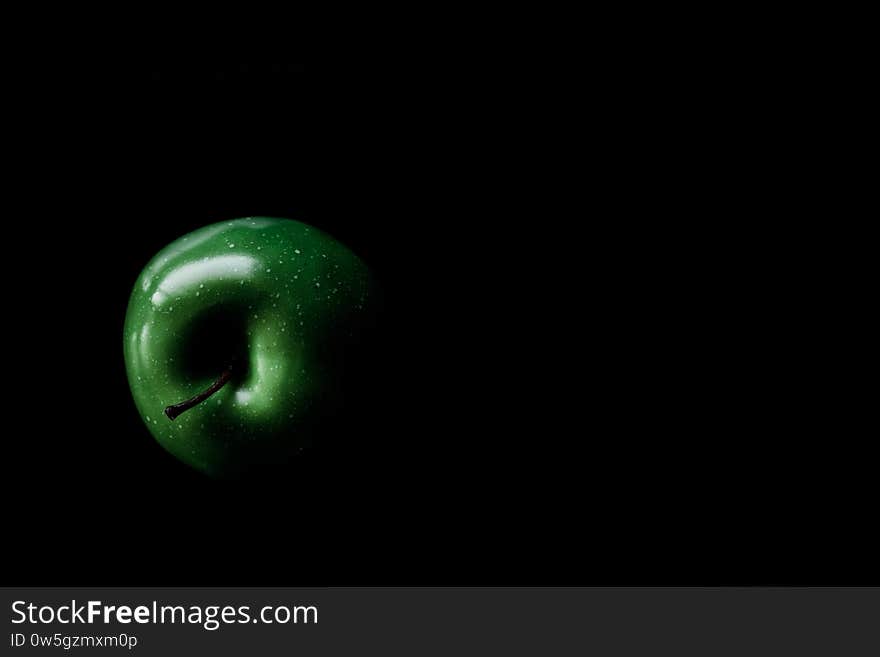 A fresh green apple isolated on a black background