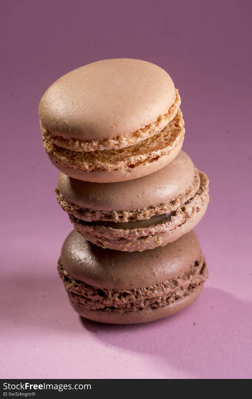 Chocolate French cookies with cocoa, hazelnuts and caramel. Close-up macro photo taken in studio on purple background. Chocolate French cookies with cocoa, hazelnuts and caramel. Close-up macro photo taken in studio on purple background.