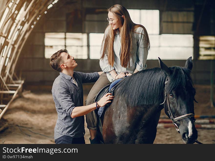 Cute loving couple with horse on ranch