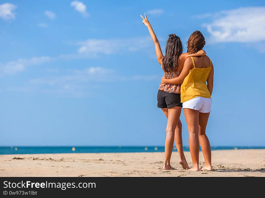 Two girls from the back on the beach