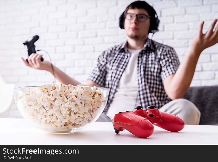 Stay home. Disappointed young man playing video games at home. Selective focus