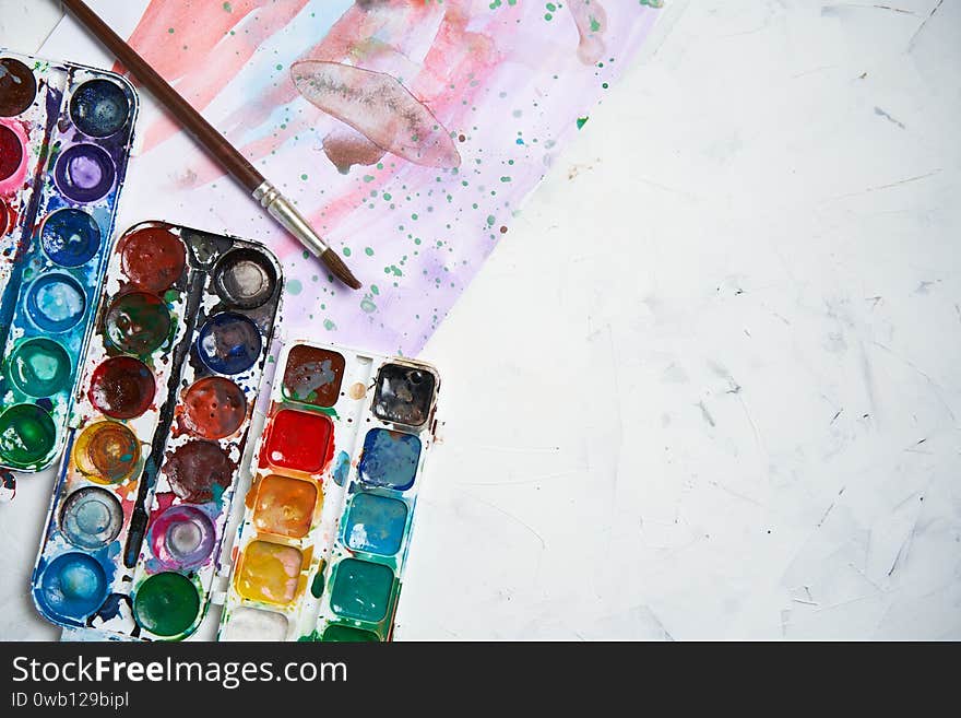 Set of watercolor paints white background. Brushes drawing. Creative background. School for teaching drawing. With copy space for text. Set of watercolor paints white background. Brushes drawing. Creative background. School for teaching drawing. With copy space for text