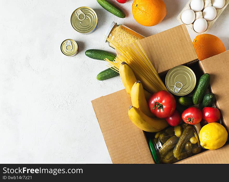 Food delivery box donation with products, canned, vegetsbles, cereal, pasta and other on white background