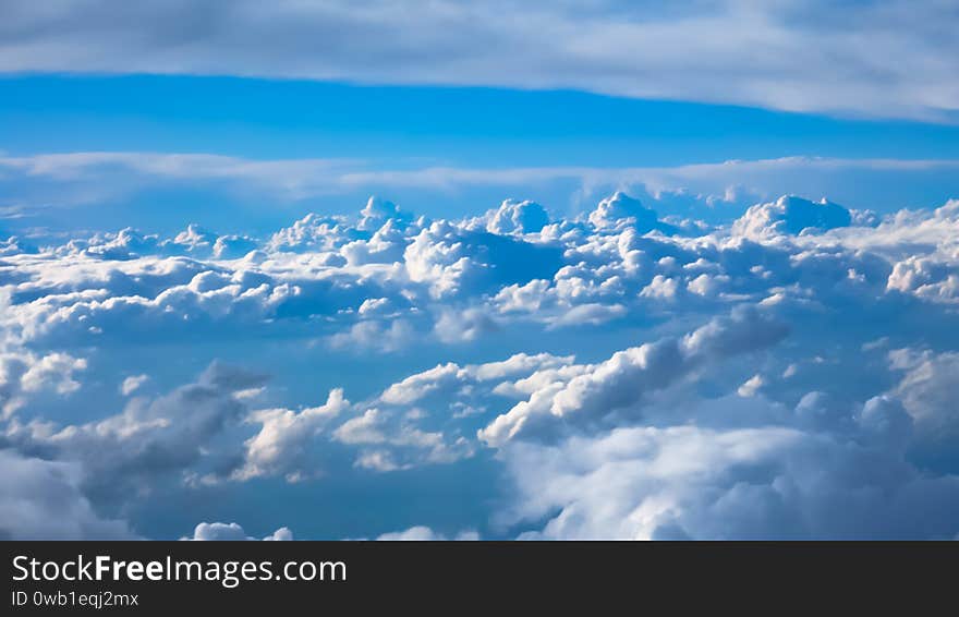 Nice footage of aerial view above clouds from airplane window with blue sky. View from the airplane window to the blue sky and white clouds.