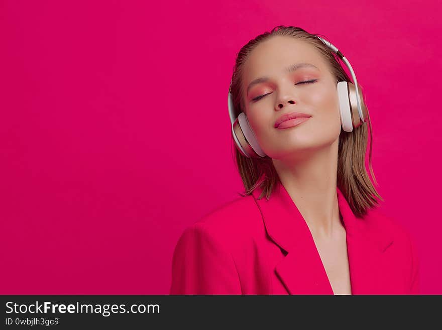 A beautiful young girl in wireless headphones listens to song with a good mood. bright colorful music poster.